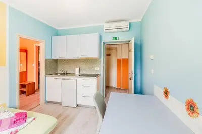 a kitchen with white cabinets and a blue wall at Apartments Orhideja in Tolmin