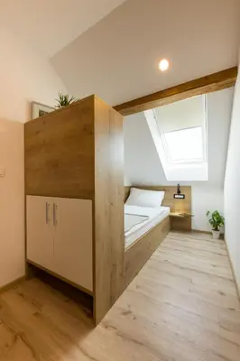 a small bedroom with a bed and a window at Apartments Repinc in Bled