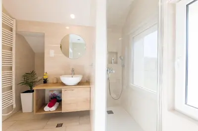 two images of a bathroom with a sink and a shower at Apartments Repinc in Bled
