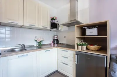 a kitchen with white cabinets and a sink at Apartments Repinc in Bled