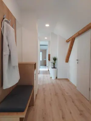 a room with a hallway with white walls and wooden floors at Apartments Repinc in Bled