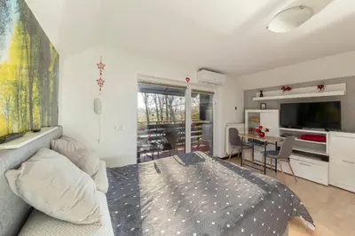 a bedroom with a bed and a table and a television at Oddih ob Krki in Škocjan