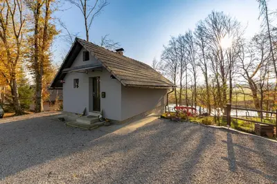 a small white house in the middle of a road at Oddih ob Krki in Škocjan
