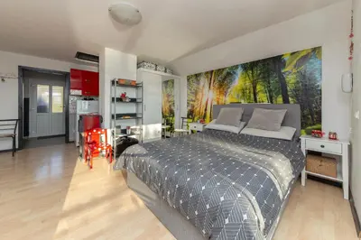 a bedroom with a bed with a painting on the wall at Oddih ob Krki in Škocjan