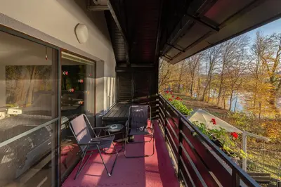 a balcony with chairs and a view of a river at Oddih ob Krki in Škocjan