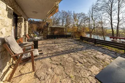 a patio with a chair and a table and a fence at Oddih ob Krki in Škocjan
