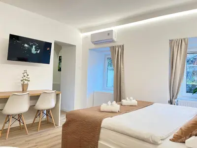 a bedroom with a bed and a desk and chairs at Under Castle Apartment in Ljubljana