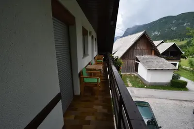 a balcony of a house with chairs and a building at Guest House Žnidar in Bohinj