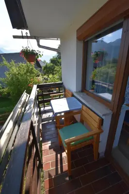 a balcony with a table and chairs and a window at Guest House Žnidar in Bohinj
