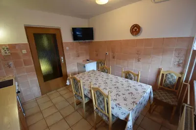 a dining room with a table and chairs and a television at Guest House Žnidar in Bohinj