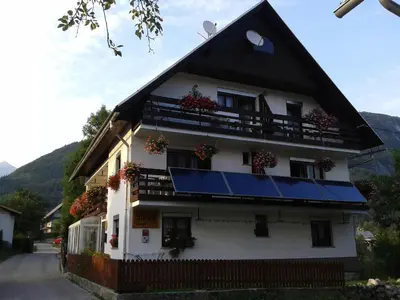 a white house with a black roof and windows at Guest House Žnidar in Bohinj