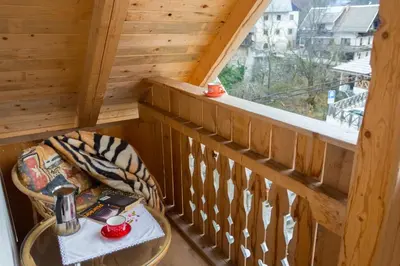 a room with a table and a balcony with a window at Apartment Ivanka Cvetek in Bohinj