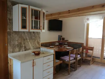 a kitchen with a table and a dining room at Apartment Ivanka Cvetek in Bohinj