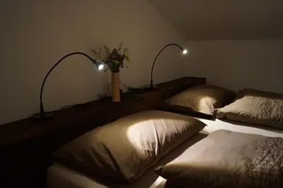 a room with two beds with pillows and two lights at Apartments Lom in Most na Soči