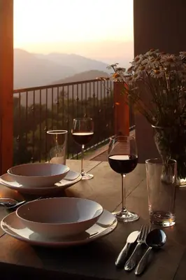a table with plates and glasses of wine on a balcony at Apartments Lom in Most na Soči