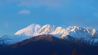 a snow covered mountain in the distance with at Apartments Lom in Most na Soči