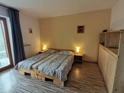 a bedroom with a bed and two lamps and a window at Apartment Rakušček in Kobarid