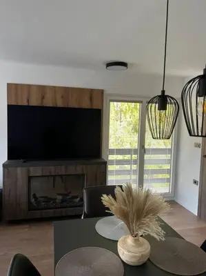a living room with a table and a fireplace at Golden hour apartment in Kranjska Gora