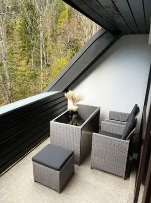 a balcony with two chairs and a table and a window at Golden hour apartment in Kranjska Gora