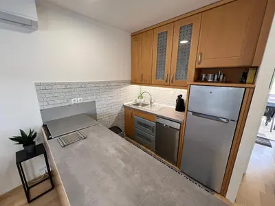 a kitchen with wooden cabinets and a stainless steel refrigerator at Vila VALENTINA in Čatež ob Savi