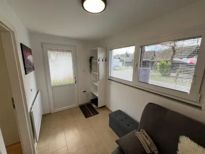 a living room with a couch and two windows at Vila VALENTINA in Čatež ob Savi