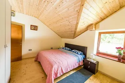 a bedroom with a bed and a wooden ceiling at Tami in Lokve