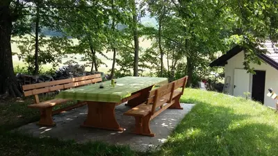 a picnic table with two benches in a park at Tami in Lokve