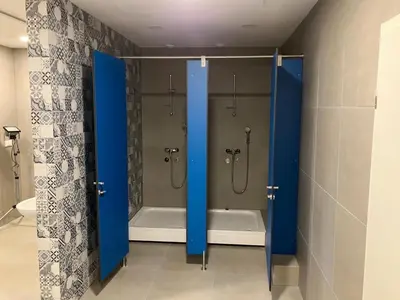 a bathroom with a shower and a tub with blue doors at CafDorm in Maribor