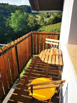 a patio with a table and a bench on a balcony at Hiška sončni hrib. in Novo Mesto