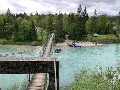 a bridge with a group of people in boats on a river at Riverhouse apartment in Radovljica