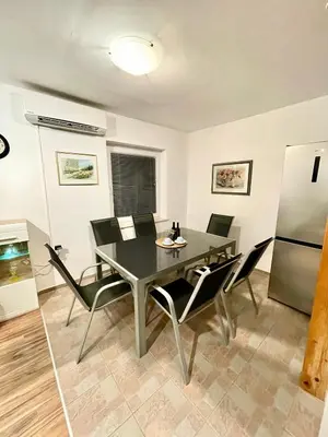 a dining room with a table and chairs and a refrigerator at Riverhouse apartment in Radovljica