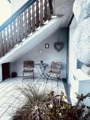 a patio with two chairs and a table and stairs at Riverhouse apartment in Radovljica