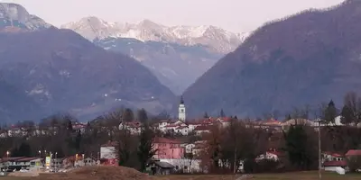 a city with mountains in the background with a town at Apartment Maruška in Tolmin