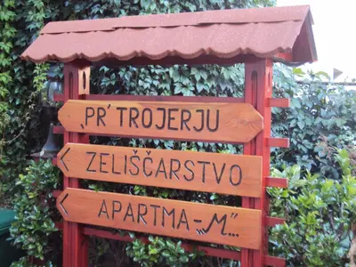 a bunch of street signs in front of a hedge at Apartment Maruška in Tolmin