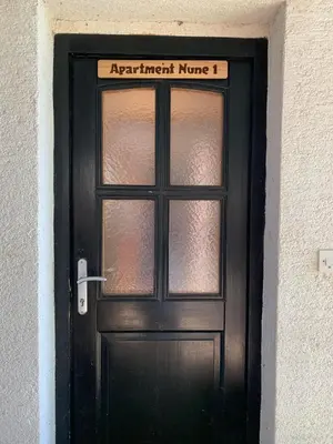 a black door with a sign on top of it at Apartments Nune 2 in Zreče