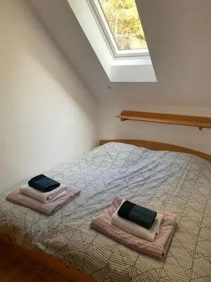 a bedroom with a bed with towels and a window at Apartments Nune 2 in Zreče