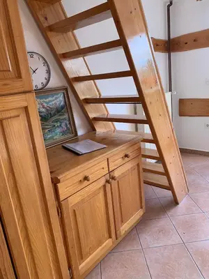 a staircase with a desk in a room with a clock at Apartments Nune 2 in Zreče
