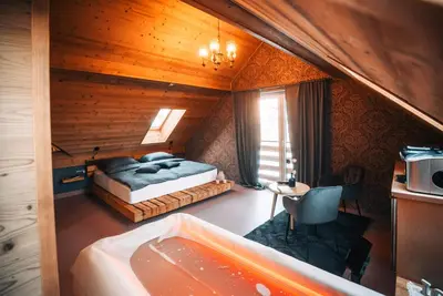 a bedroom with a bed and a tub in a room at Posest Kunigunda in Šmartno v Rožni Dolini