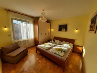 a small bedroom with a bed and a chair at Chalet and Apartment Žonir with SAUNA in Kobarid