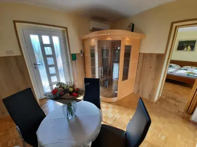 a dining room with a table and chairs and a bedroom at Chalet and Apartment Žonir with SAUNA in Kobarid