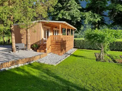 a small wooden cabin in a yard with grass at Chalet and Apartment Žonir with SAUNA in Kobarid