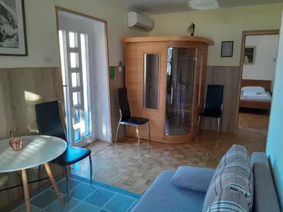 a living room with a couch and a table and chairs at Chalet and Apartment Žonir with SAUNA in Kobarid