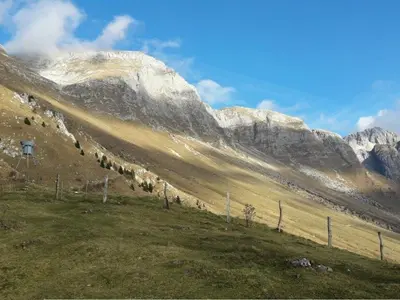 a field with a fence in front of a mountain at Chalet and Apartment Žonir with SAUNA in Kobarid