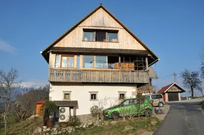a house with a green car parked in front of it at Apartment Sonca in Bled