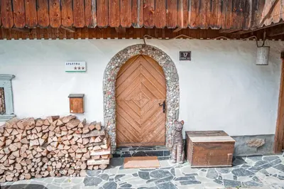 a wooden door in a wall with a pile of wood at Apartment Sonca in Bled