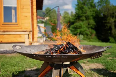a grill with a fire in it in a yard at Apartment Bon in Kobarid