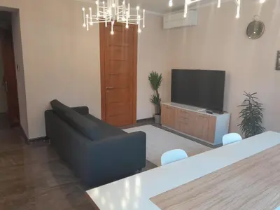 a living room with a couch and a flat screen tv at Deluxe Central Apartment in Ljubljana