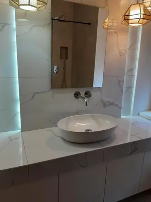 a bathroom with a white sink and a mirror at Deluxe Central Apartment in Ljubljana