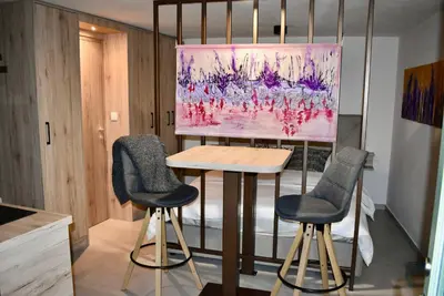a table and two chairs in a room with a painting at Vila Imenja in Šmartno