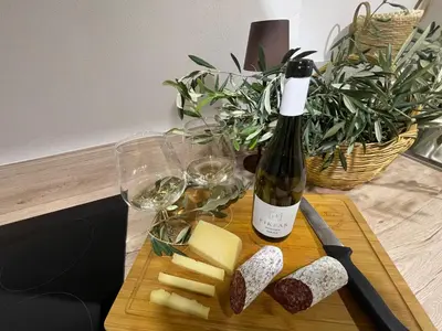 a bottle of wine and cheese on a cutting board at Vila Imenja in Šmartno